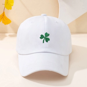 White cotton baseball cap with green clover embroidery on curved brim in 45-degree angle