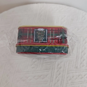 Detail of Christmas tin box with red and green plaid pattern and a festive tree