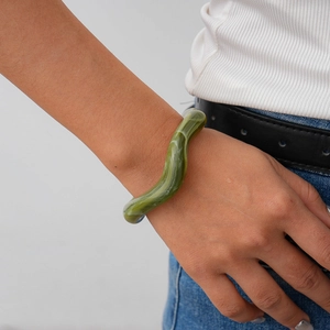 Detail of green marble acrylic wave bangle shown on wrist in a bohemian vintage style