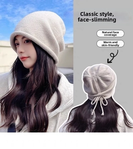 Detail view of cream knit beanie featuring adjustable drawstring and rolled edge design