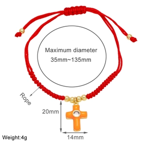 Detail of red rope bracelet showing the 20x14mm orange enamel cross charm with zircon