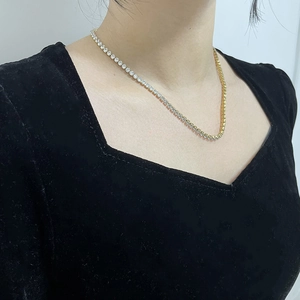 Detail of a two-tone gold and silver tennis necklace with clear cubic zirconia stones