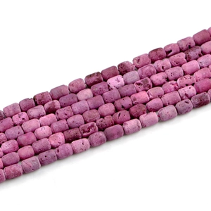 Macro shot of purple geode agate barrel beads with natural stone texture on white back