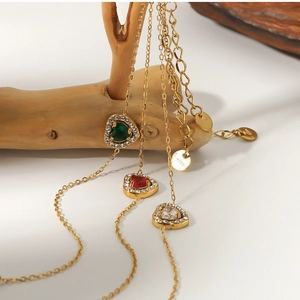 Close-up of heart-shaped zircon pendants in red, green and clear on 18K gold plated chains