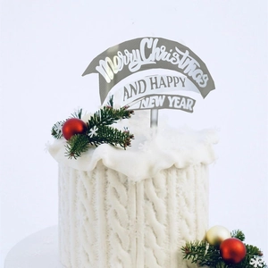 Silver Merry Christmas cake topper on white knit textured cake with festive pine decor