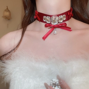 Close-up of elegant red velvet choker with crystal inlay and teardrop pearl drop