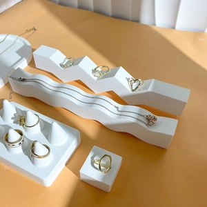 Minimalist white plaster jewelry display set for rings and necklaces on orange background