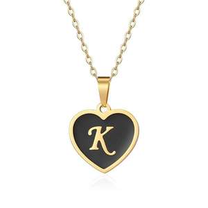 Detailed close-up of gold heart pendant with black enamel inlay and cursive letter K
