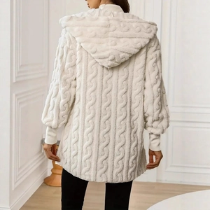 Detail view of the elegant cream cable-knit texture and hooded back on this warm jacket