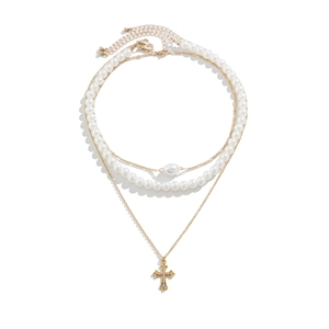 Close-up of multilayer beaded necklace with white pearls, gold chains and cross pendant