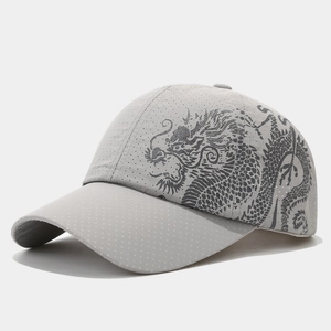 Detail of laser-cut breathable holes and dragon print on a grey quick-dry baseball cap