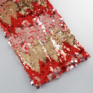 Close-up of shimmering red and gold sequins with sharp texture and bright lighting detail