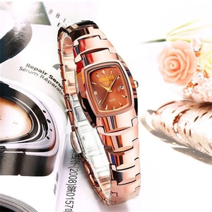 Detail view of rose gold quartz watch with a tonneau-shaped dial and crystal markers