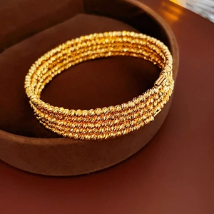 Close-up of gold-plated multi-layer beaded bracelet in a premium velvet jewelry box