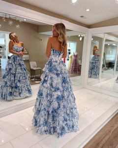 Three-way view of a floral strapless corset evening gown with multi-layered tiered skirt