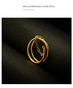 Detailed close-up of golden double-layer chain ring on textured black background