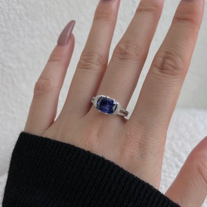 Detail of S925 silver ring featuring blue cushion-cut gemstone with halo diamond setting