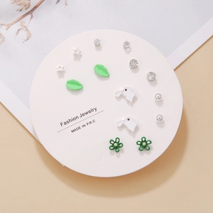 Detail of seven pairs of assorted tassel earrings on a white circular display card