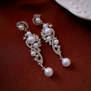 Luxurious silver long tassel earrings with pearls and rhinestones on velvet background