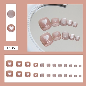 Pink cat eye press-on toenails with white heart patterns and gold trim detailing