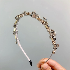 Dettaglio di perle di cristallo grigio scintillanti su un cerchietto metallico sottile