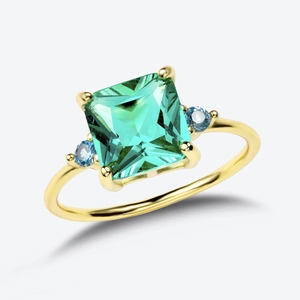 Detailed view of square green emerald and blue side stones on gold silver ring