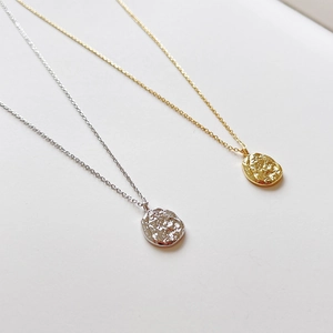 Detailed view of gold and silver coin necklaces with unique hammered texture surface