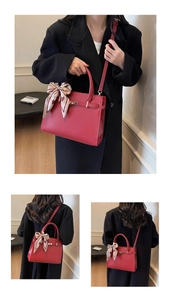 Détail du sac à main de mariée rouge avec boucles dorées et foulard décoratif en soie