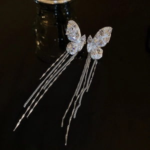 Detailed view of silver butterfly ear cuff with shimmering zircon and long tassel chains