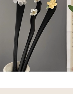 Detailed view of handcrafted wooden hairpin with elegant white and yellow floral accents