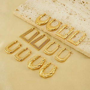 Golden titanium steel hoop earrings set with textured geometric patterns on stone