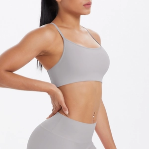 Détail montrant les fines bretelles et le dos croisé du soutien-gorge de yoga gris clair