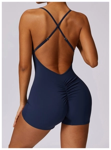 Detail of cross back straps and ruched lifting seam on navy blue yoga bodysuit