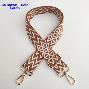 Detail of wave pattern woven bag strap with golden swivel hook and metal buckle