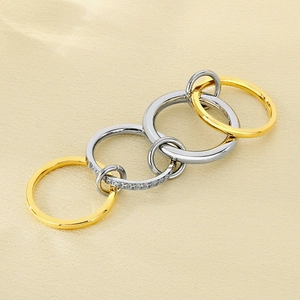 Macro detail of intertwined multi-layer stainless steel rings with sparkling zircon inlay