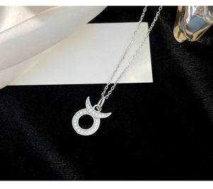 Detailed view of silver zodiac necklace featuring a crescent moon with zircon on black velvet