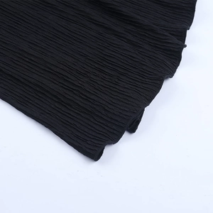 Gros plan sur la texture du tissu plissé noir et la finition côtelée verticale