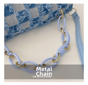 Détail du sac en denim à damier bleu avec chaîne en acrylique et métal doré