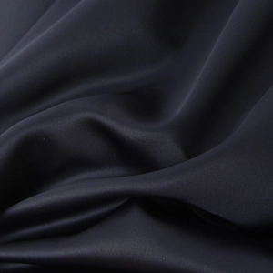 Détail du tissu satiné brillant d'une robe dos nu bouffante avec des plis élégants