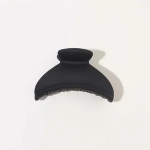 Detail of matte black shark hair claw clip with smooth crescent moon design for women