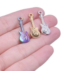 Detailed macro shot of three guitar-shaped metal pendants in gold, silver, and rainbow colors