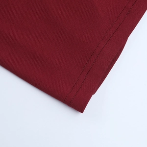 Vue détaillée de la texture du tissu en maille côtelée bordeaux avec coutures précises