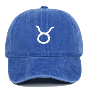 Detail of blue washed cotton baseball cap featuring white Taurus zodiac embroidery