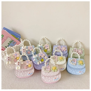 Detail of macaron mini lace bags with pearl handles and cute plush bear charms