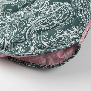 Detail of teal and pink paisley fabric layers with high-quality stitching on the jacket