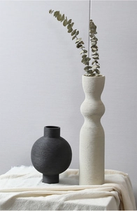 Detail of matte textured ceramic vases with horizontal brushed stripes in a modern set