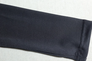 Close-up of neatly stitched black knit cuff showing high-quality sewing and fabric texture