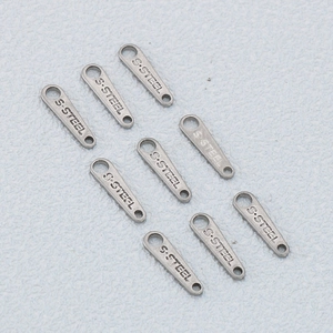 Macro shot of silver stainless steel chain tags with dual holes and S.STEEL engraving