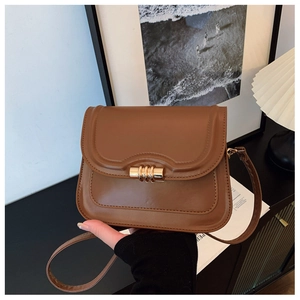 Détail du sac besace vintage en cuir marron avec boucle en métal doré et rabat élégant