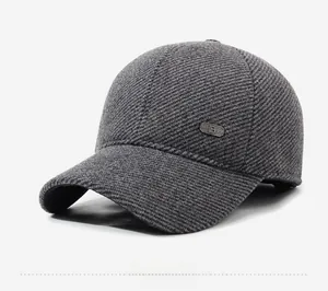 Close-up of dark grey winter baseball cap showing thick twill wool texture and metal side tag